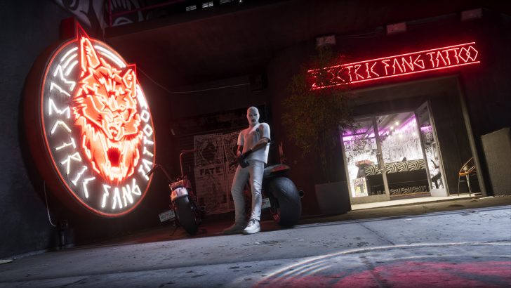 A masked character stands next to a motorcycle outside a tattoo parlour with neon signs reading 'Electric Fang Tattoo' in an urban setting.