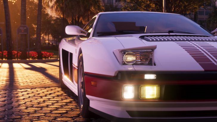 A detailed close-up of a white sports car with distinctive red racing stripes on the hood, shown parked on a sunlit, cobblestone street, with trees and flower beds in the background.