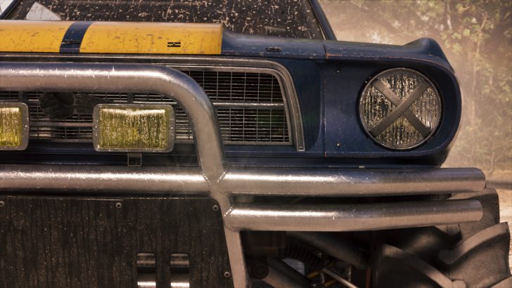 A close-up of a rugged vintage off-road vehicle's front grille and bumper, featuring round and rectangular headlights with a weathered appearance.
