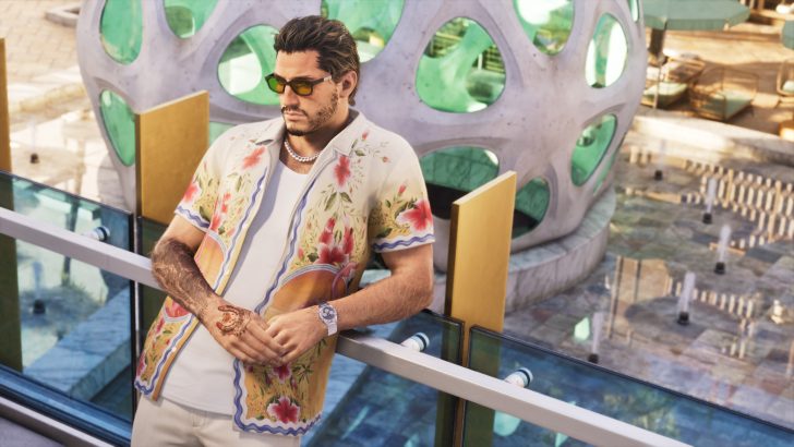 A character in the game Grand Theft Auto V leans against a glass railing, wearing sunglasses and a floral shirt.