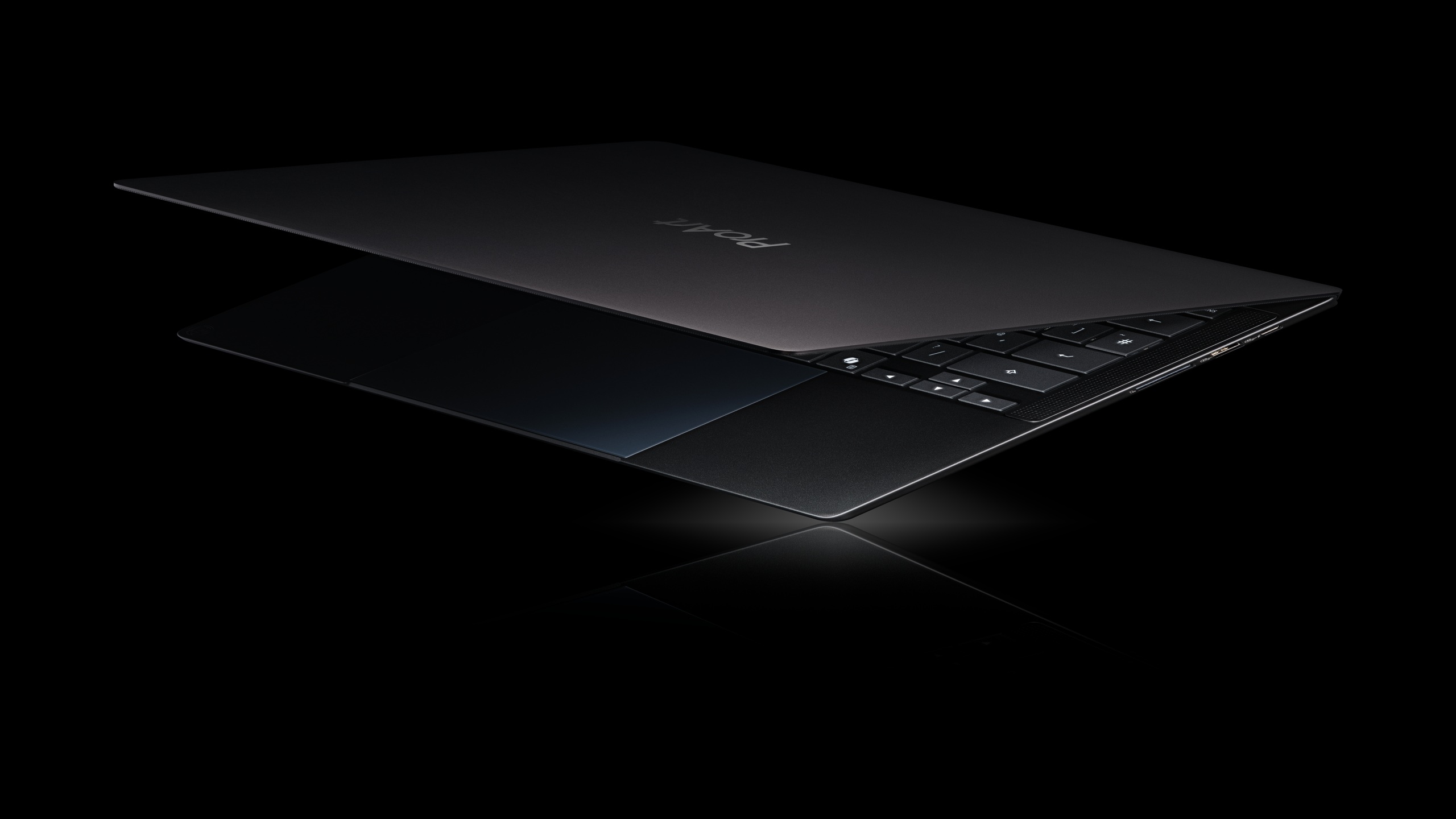 A partially opened black laptop with the brand name POKE visible on the lid, set against a black background.