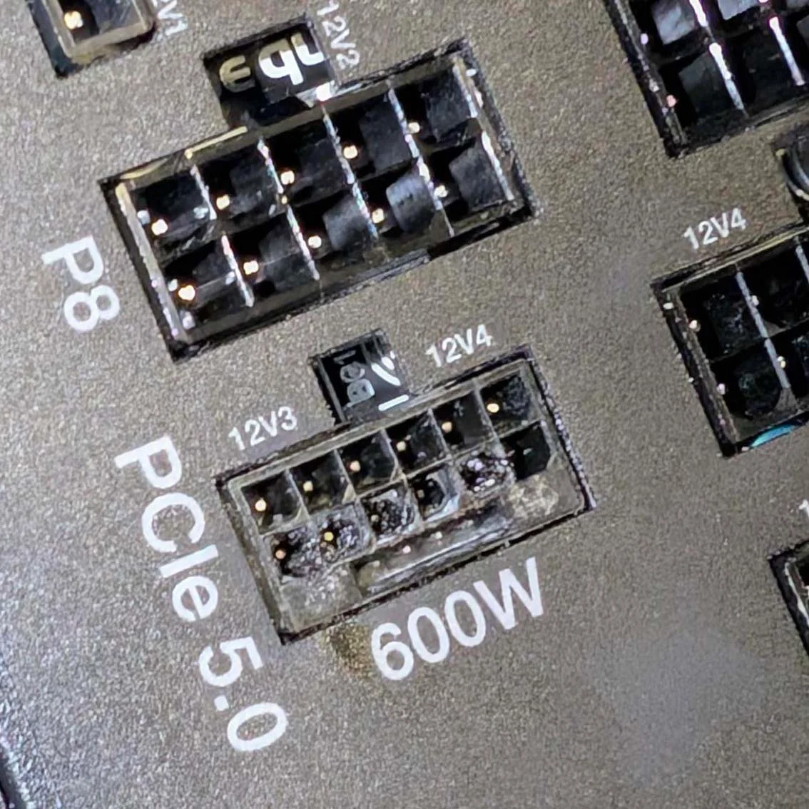 A close-up of a 'PCIe 5.0' 600W power connector shows visible damage and discoloration on the pins.