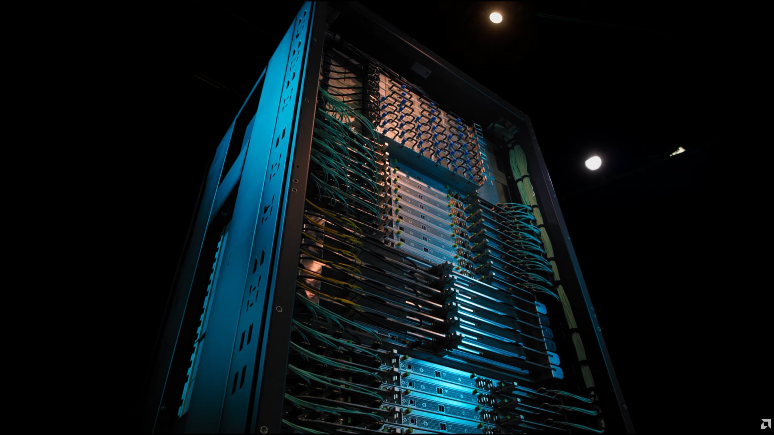 A large server rack filled with multiple network cables and computing hardware, viewed from a low angle in a dimly lit data center.