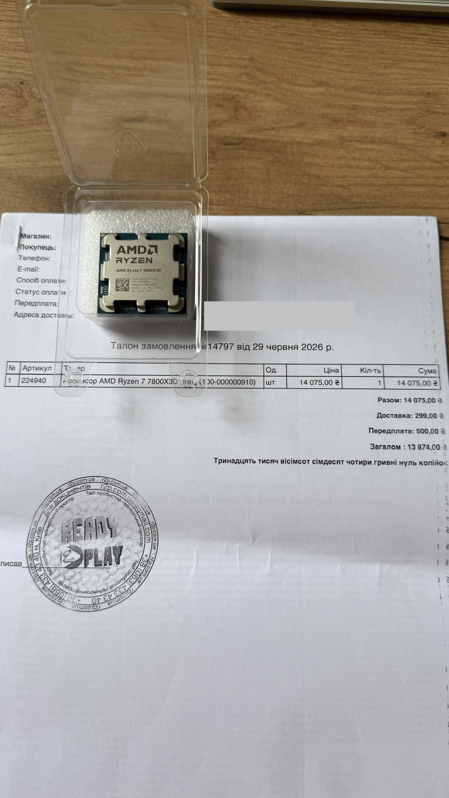 An AMD Ryzen 7 7800X3D processor in a clear case is placed on a purchase document labeled with the same model number.