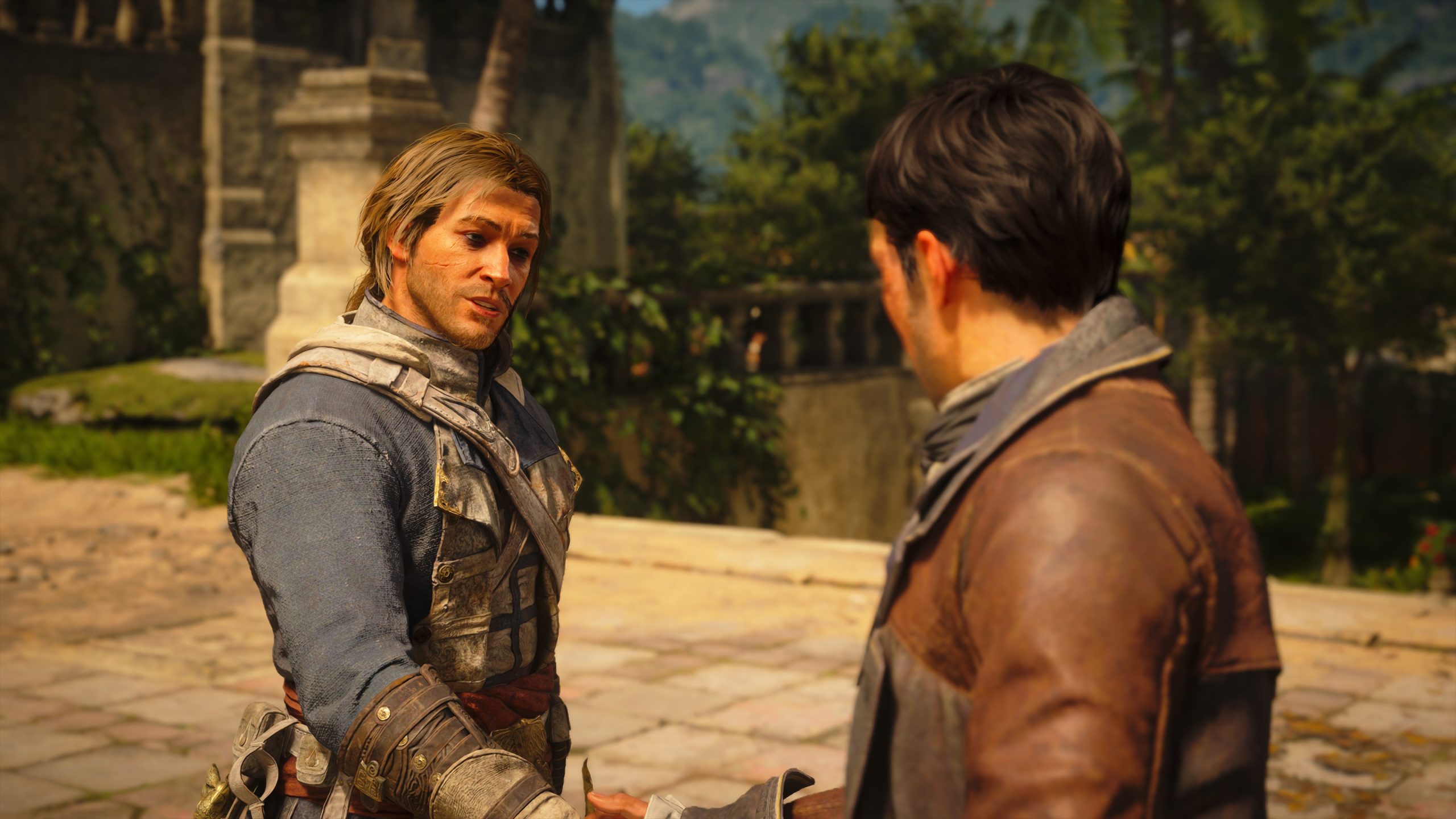 A scene from the video game Uncharted, showing two characters, one in a blue jacket and the other in a brown leather jacket, conversing in an outdoor historical setting.