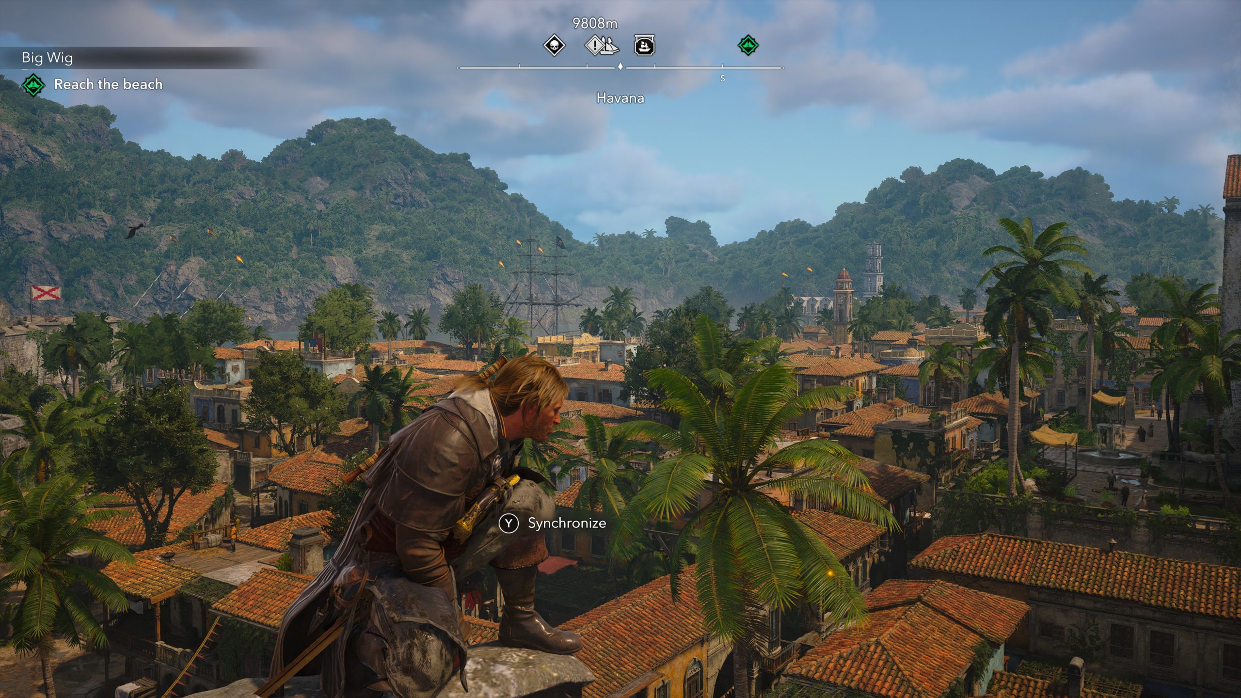 A character from 'Assassin's Creed IV: Black Flag' crouches on a rooftop overlooking the vibrant city of Havana with the objective 'Reach the beach' displayed on screen.