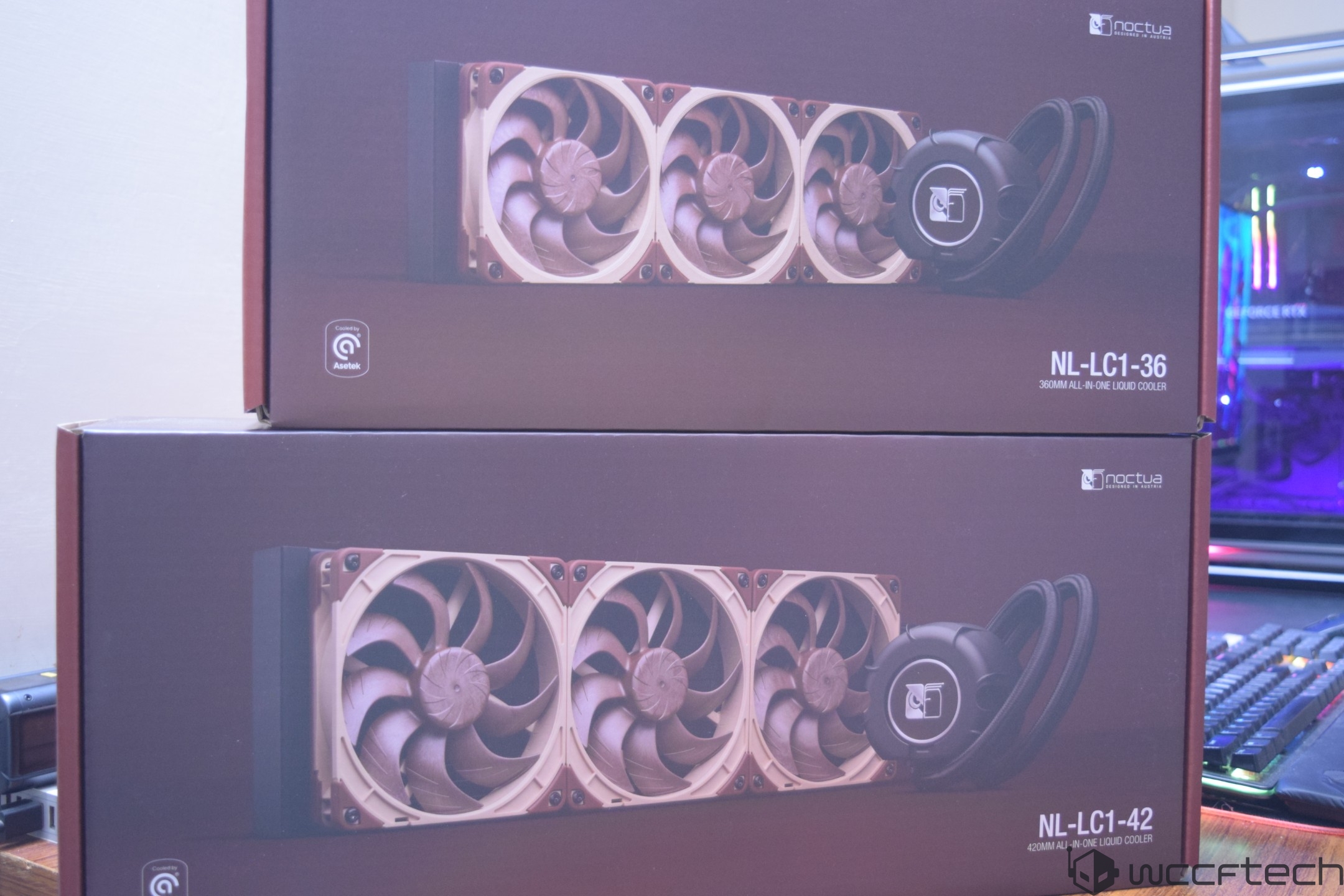 Packaging of Noctua NL-LC1-36 and NL-LC1-42 all-in-one liquid coolers displayed on a table.