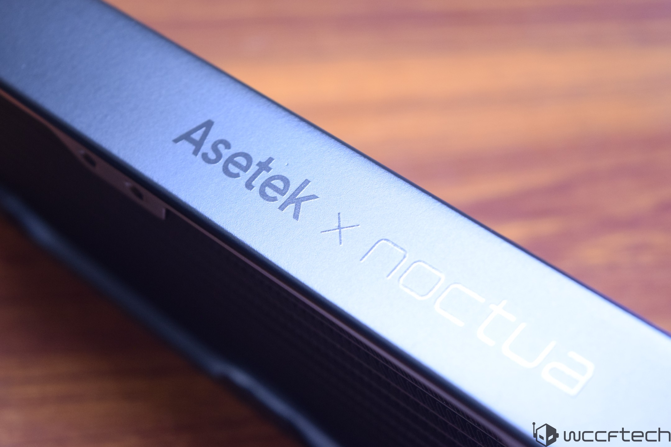 Close-up of a cooling product featuring the 'Asetek x Noctua' branding on its sleek surface.