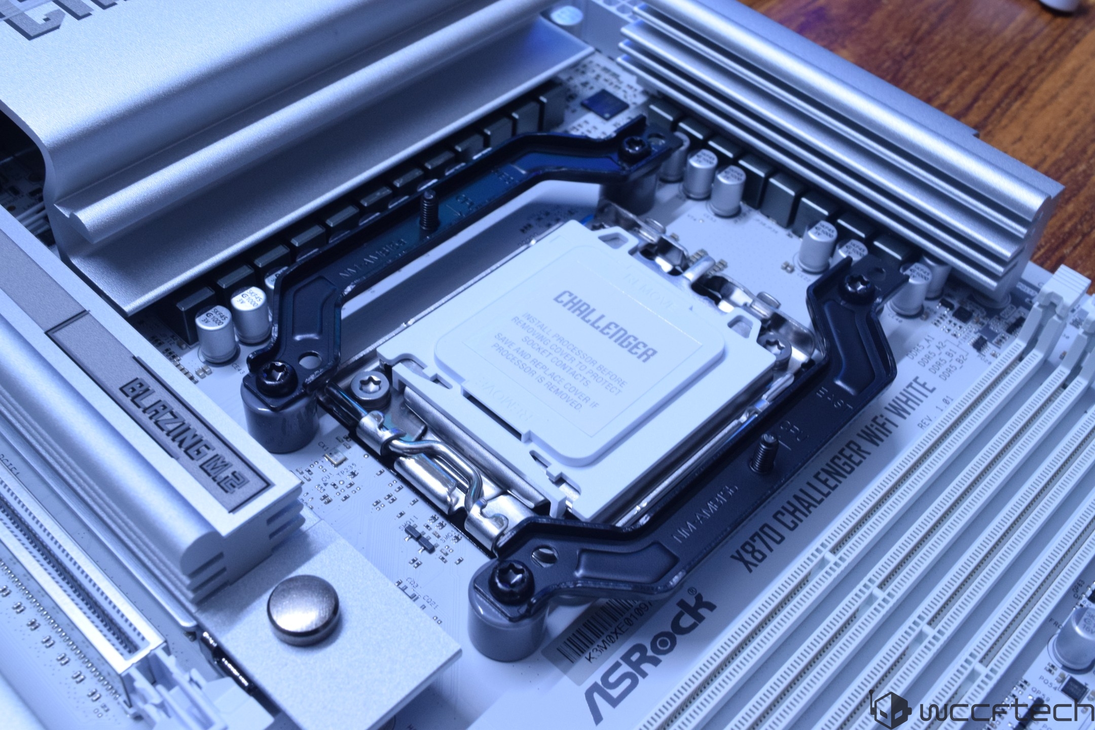 An ASRock X670E Challenger WiFi motherboard with an installed processor labeled 'CHALLENGER' is shown with the heatsink marked 'BLAZING M.2'.