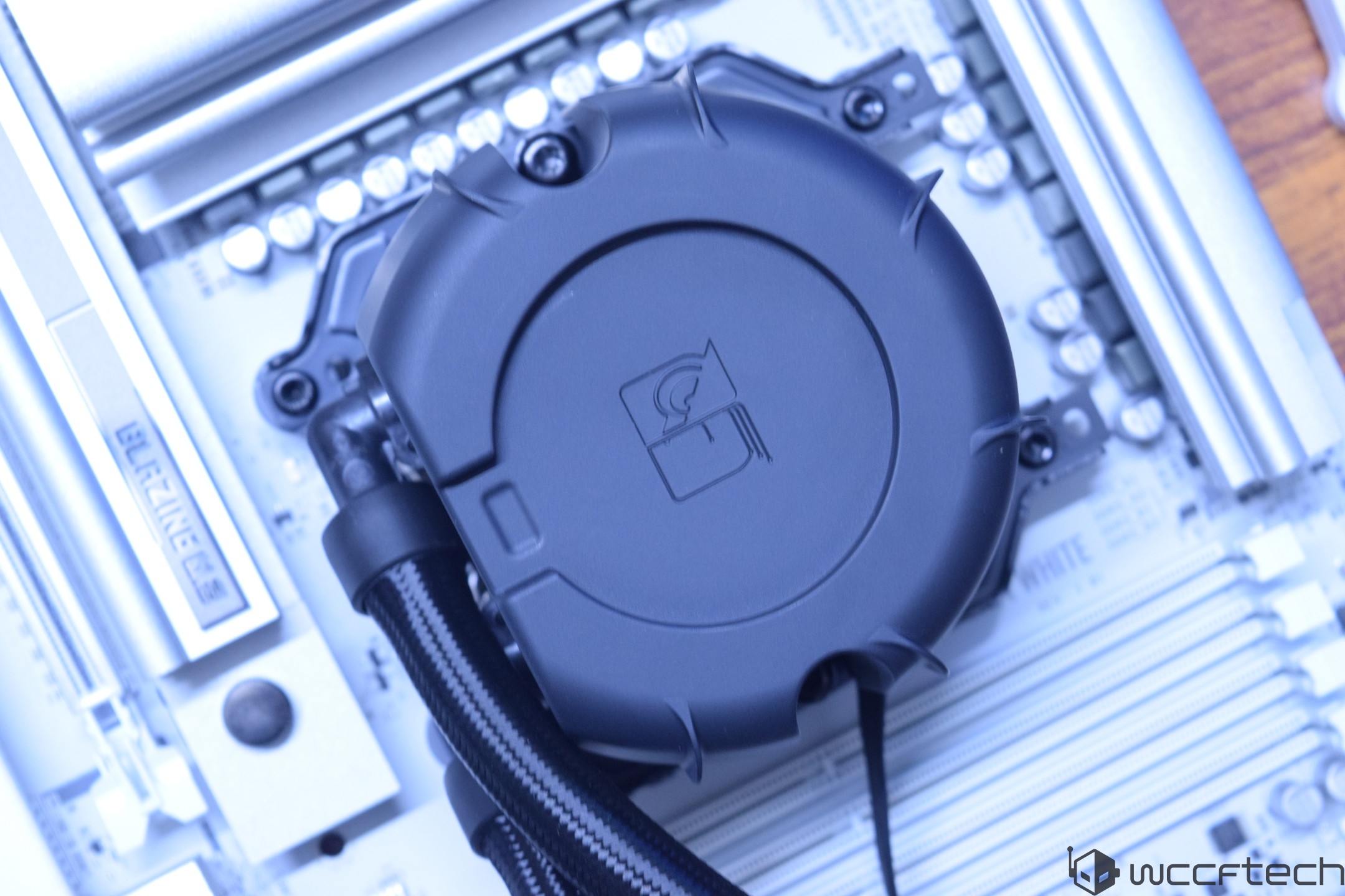 A PC motherboard with a circular CPU cooler attached, featuring a 'BLAZING' label on the side.