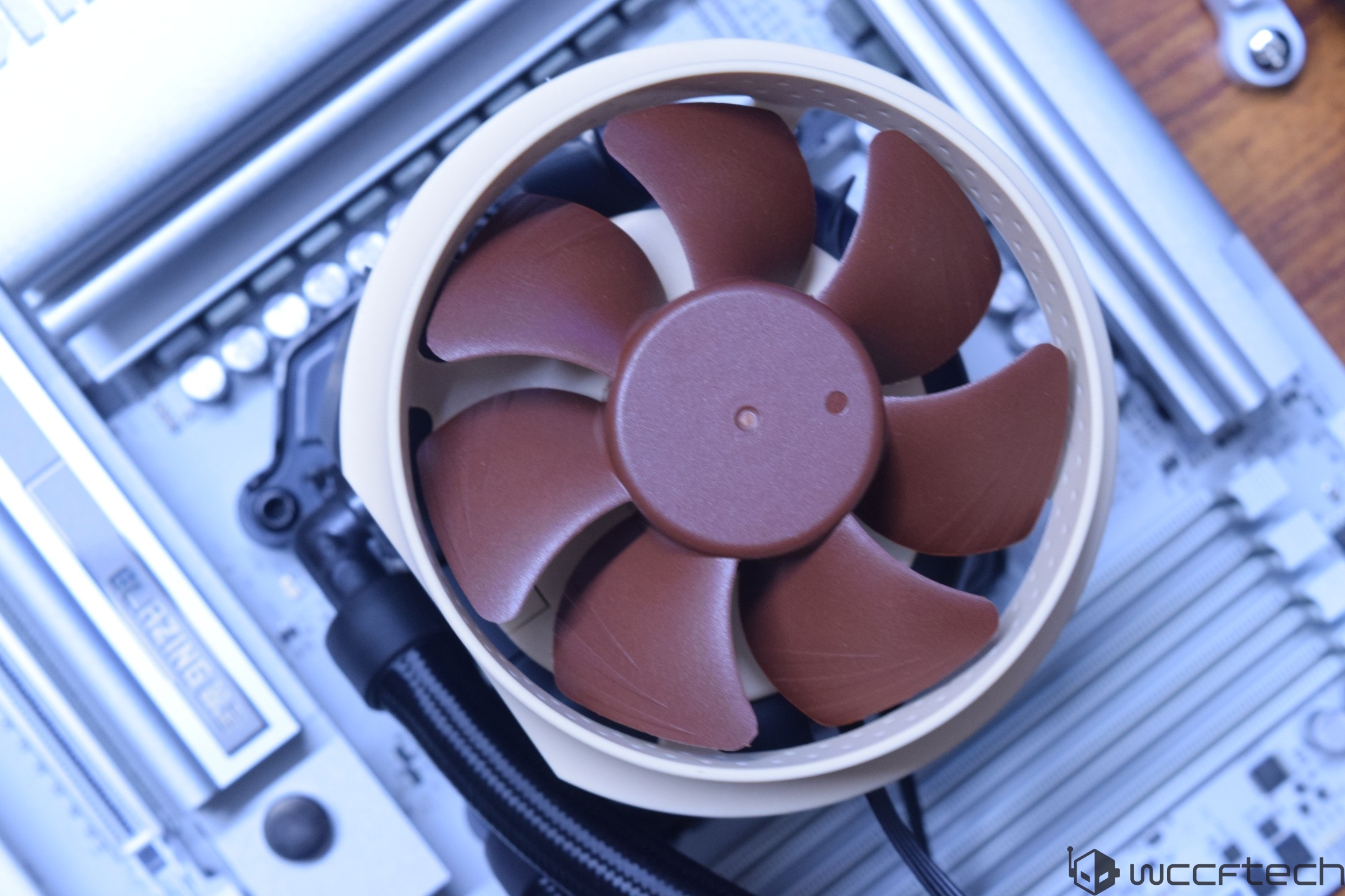 A close-up of a Noctua cooling fan installed on a motherboard with visible 'BLAZING' text near the CPU socket.