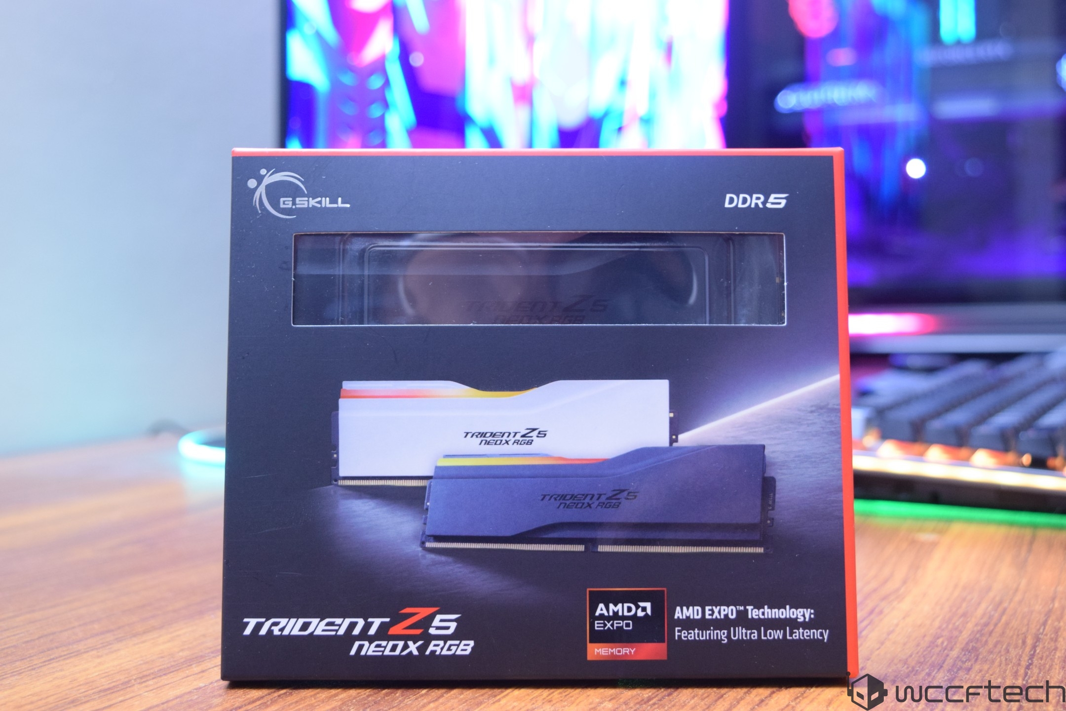 A G.SKILL Trident Z5 NEO X RGB DDR5 RAM package is displayed on a desk, highlighting 'AMD EXPO Technology' and featuring 'Ultra Low Latency'.