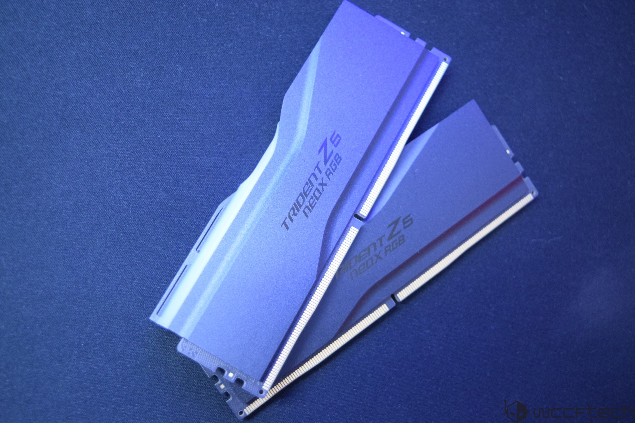 Two G.Skill Trident Z5 NEO X RGB RAM sticks on a blue surface.