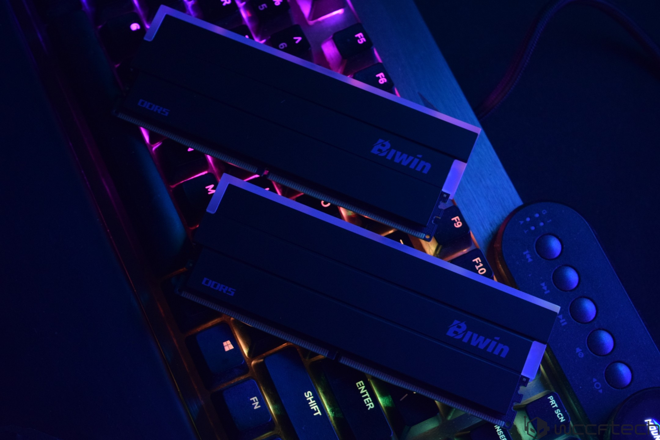 Two Biwin DDR5 memory modules placed on an RGB-backlit keyboard.