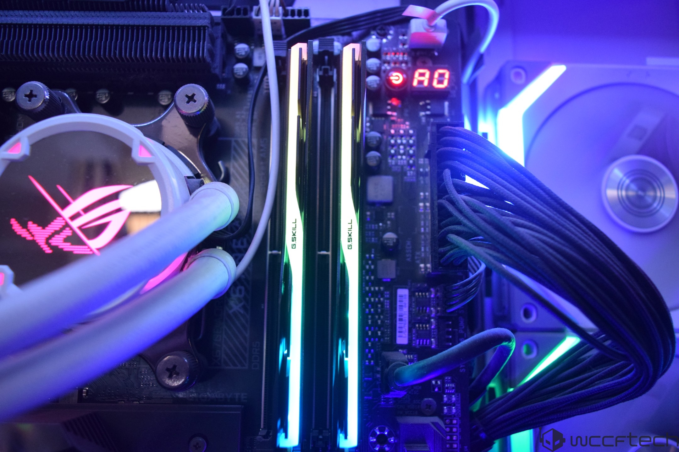 A desktop PC build featuring a ROG liquid cooler and two illuminated G.Skill RAM sticks installed on a Gigabyte motherboard.