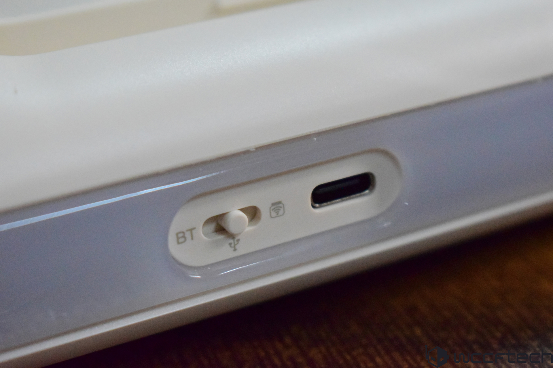 A close-up of a keyboard or device showing a switch labeled 'BT' and a USB-C port.