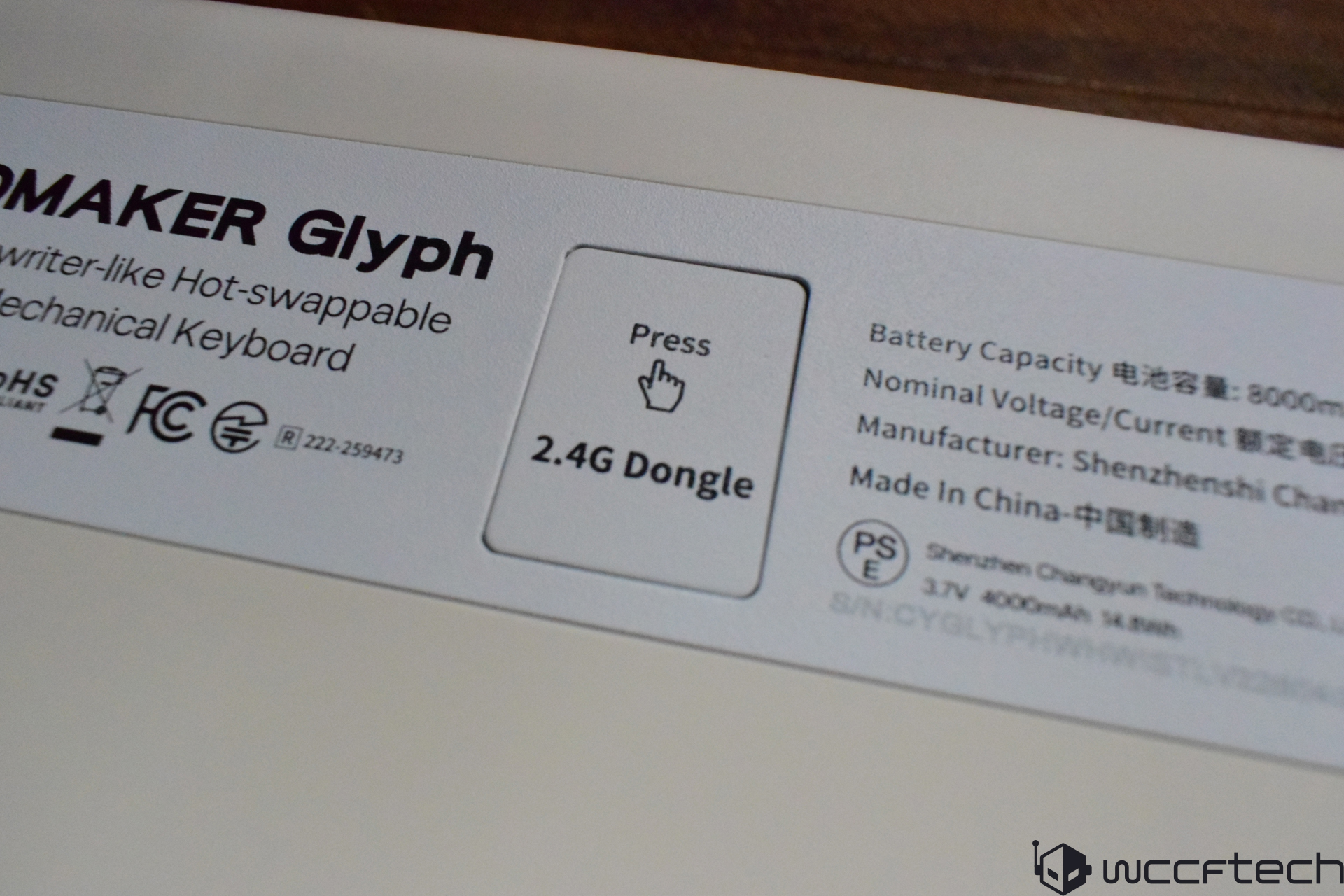 The image shows the back of a Domaker Glyph mechanical keyboard featuring labels like 'Press 2.4G Dongle' and product specifications indicating an 8000mAh battery capacity, made by Shenzhen Changrun Technology Co., Ltd.