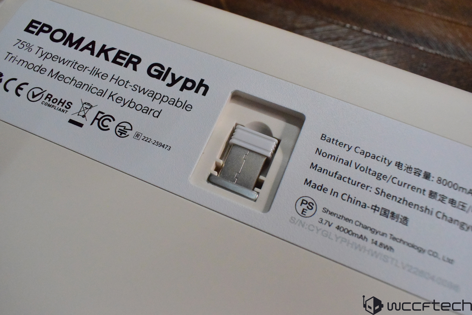 The image shows the back of an Epomaker Glyph 75% typewriter-like hot-swappable tri-mode mechanical keyboard, displaying certification logos and specifications such as an 8000mAh battery capacity.