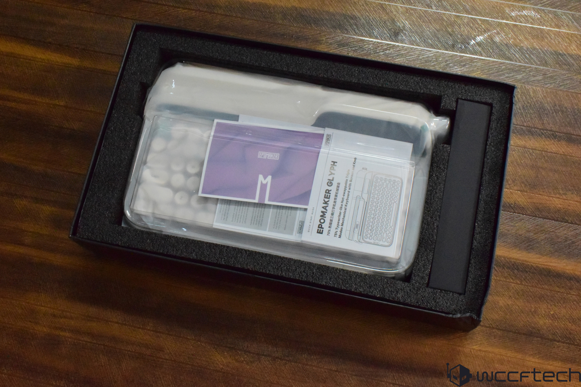 Packaging of the Epomaker Glyph mechanical keyboard is shown, with a visible instruction manual inside.