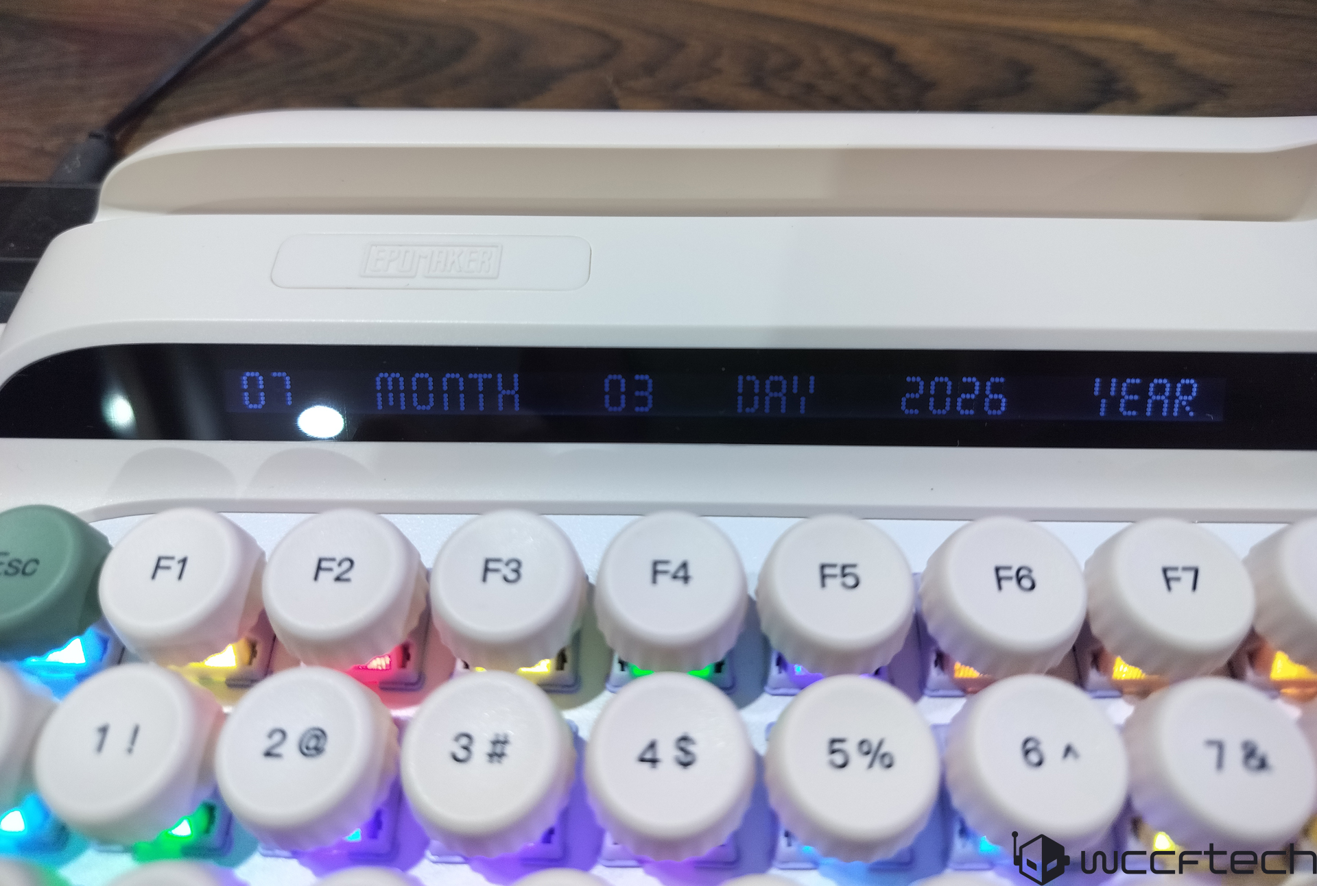 A white EPOMAKER keyboard displays '07 MONTH 03 DAY 2026 YEAR' on its screen above RGB backlit function keys.