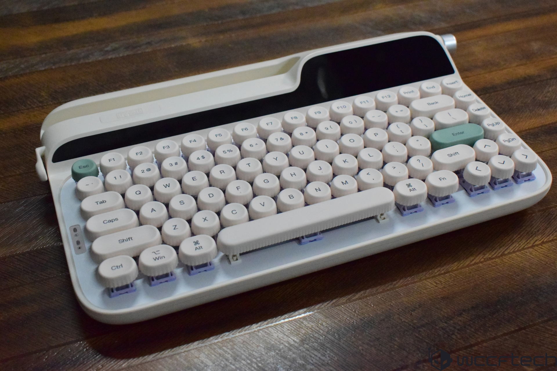 A wireless mechanical keyboard with round keycaps and a retro design is displayed on a wooden table.