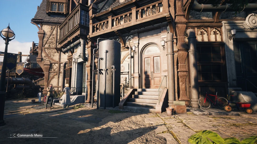Two characters stand outside a detailed, medieval-style building in a town scene from the game 'Sand Land,' with the text 'C Commands Menu' visible.
