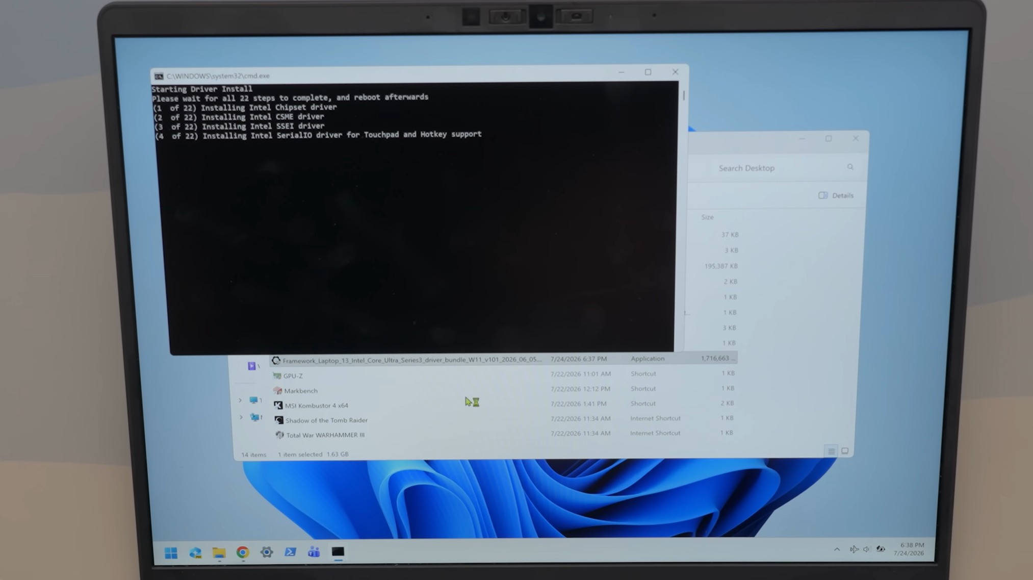A laptop screen displays a command prompt installing drivers with visible text stating, Starting Driver Install and listing steps including Installing Intel Chipset driver, alongside a file explorer window showing a driver bundle named Framework_Laptop_13_Intel_Core_Ultra_Series3_driver_bundle_W11_2026.