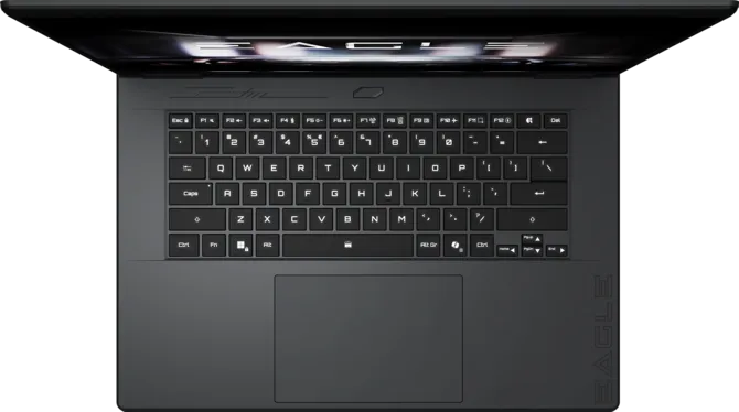 The top view of a black XMG laptop shows a full keyboard layout with 'EAGLE' partially visible on the screen and the laptop body.