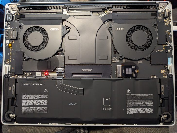 The internals of a laptop prototype labeled 'PROTOTYPE: NOT FOR SALE' with dual cooling fans and a visible battery.
