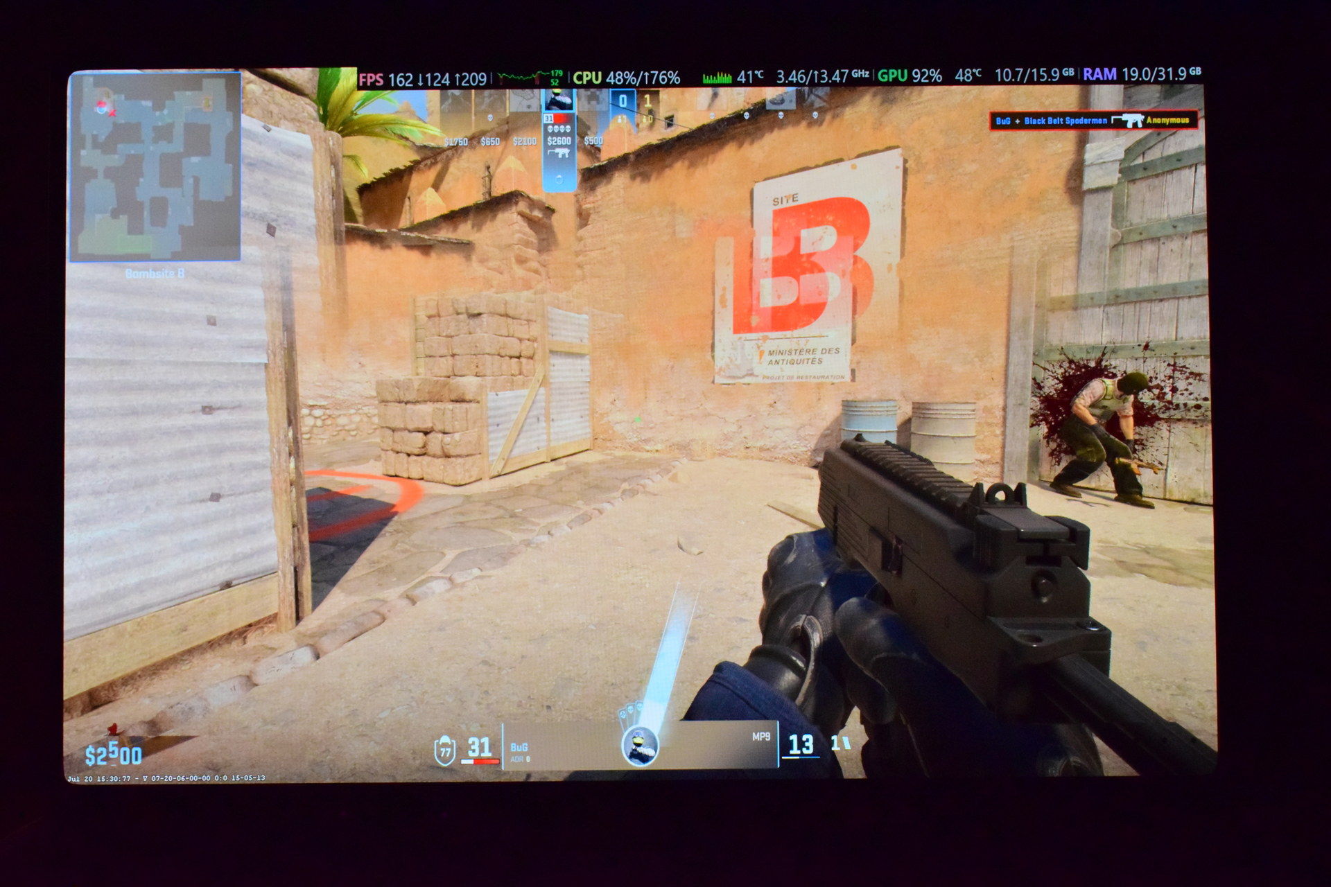 A first-person view in 'Counter-Strike: Global Offensive' (CS: GO) shows a player wielding an MP9 submachine gun with an opponent injured in the background, while the on-screen display indicates 'FPS 162 | 124 | 209'.