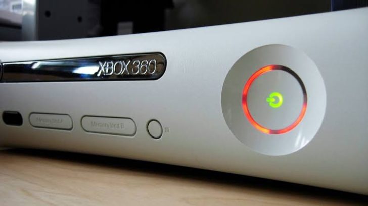 A close-up of an Xbox 360 console showing the infamous 'Red Ring of Death' light.