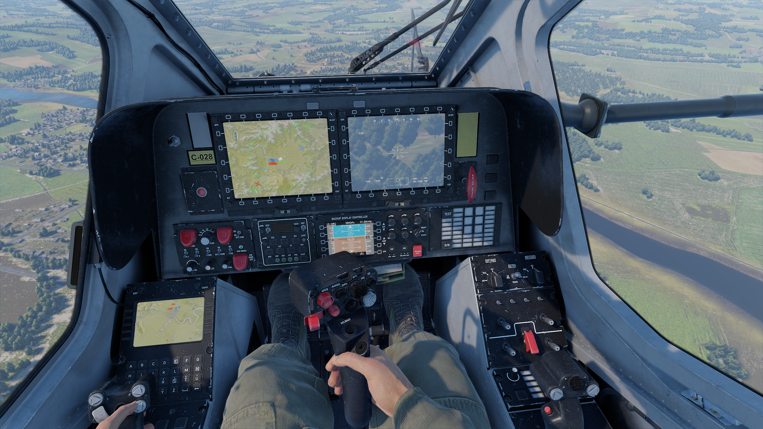 A cockpit view in a flight simulation game shows a pilot holding a joystick, with two digital map displays and a control panel labeled 'Backup Display Controller,' over a landscape featuring fields and a river.