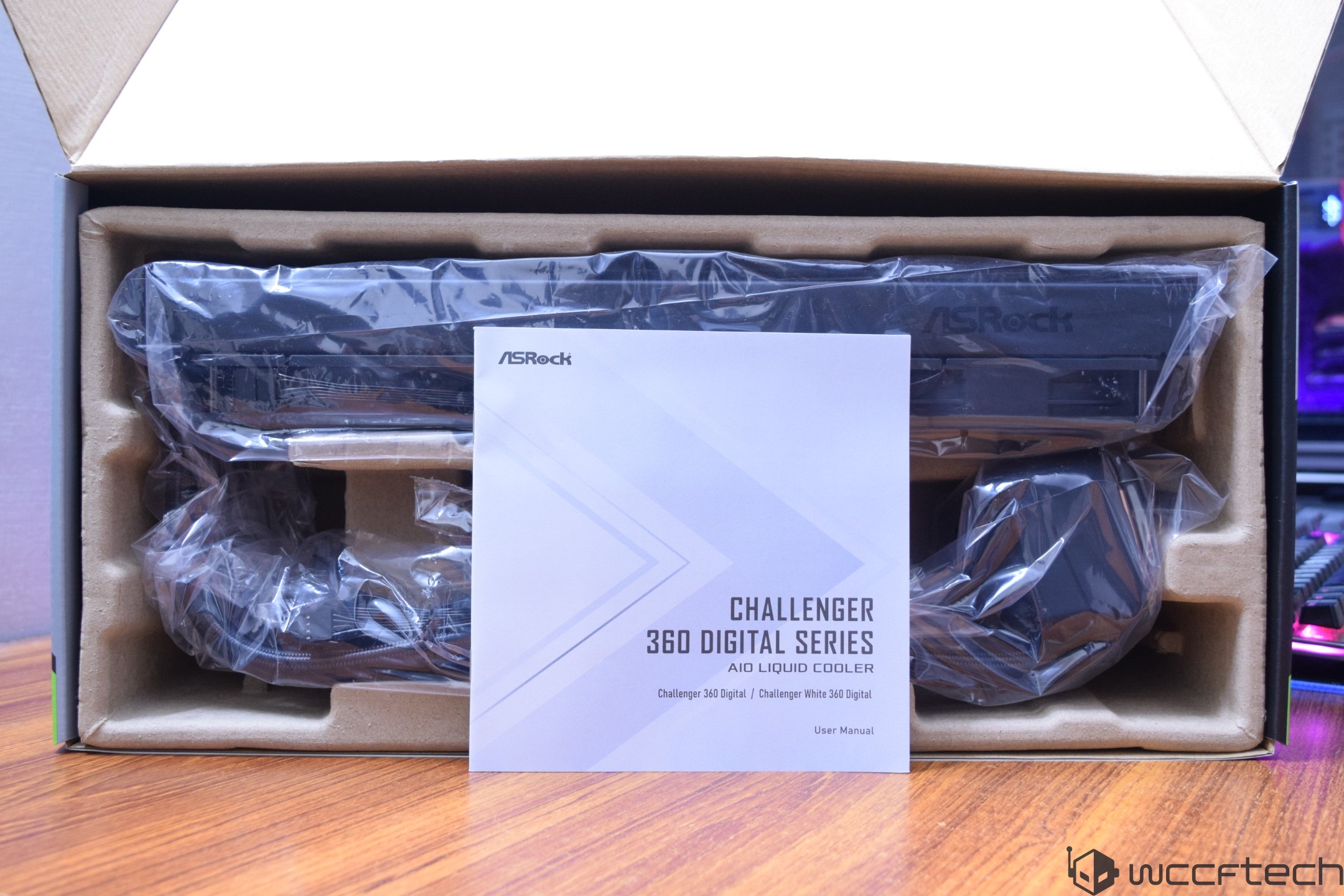 An ASRock Challenger 360 Digital Series AIO liquid cooler is partially unpacked from its box, accompanied by a user manual.