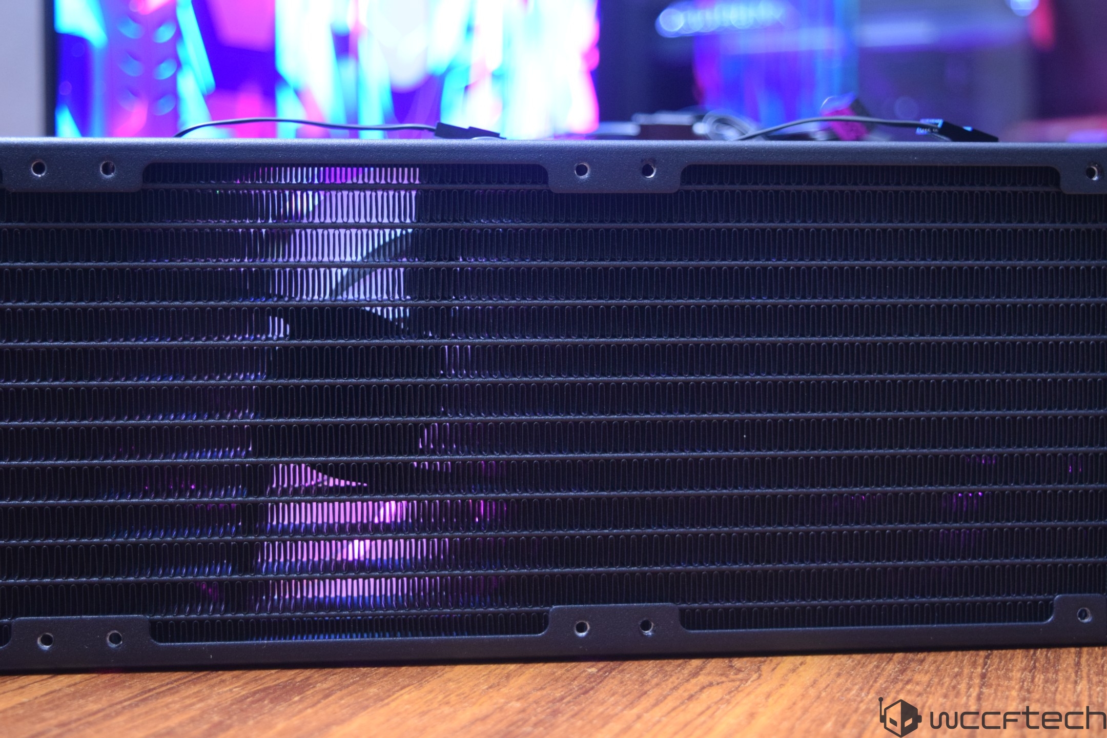 A close-up of an unbranded computer radiator with illuminated RGB colors in the background.