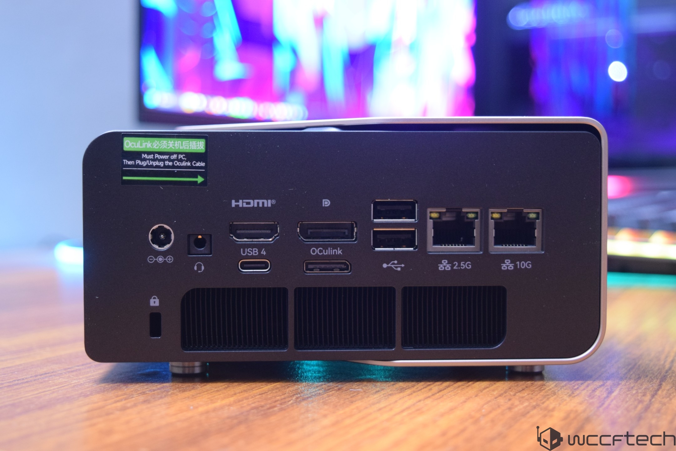 A compact computer features multiple ports, including HDMI, USB 4, OCuLink, two Ethernet ports labeled '2.5G' and '10G', and a note advising to power off the PC before plugging or unplugging the OCuLink cable.