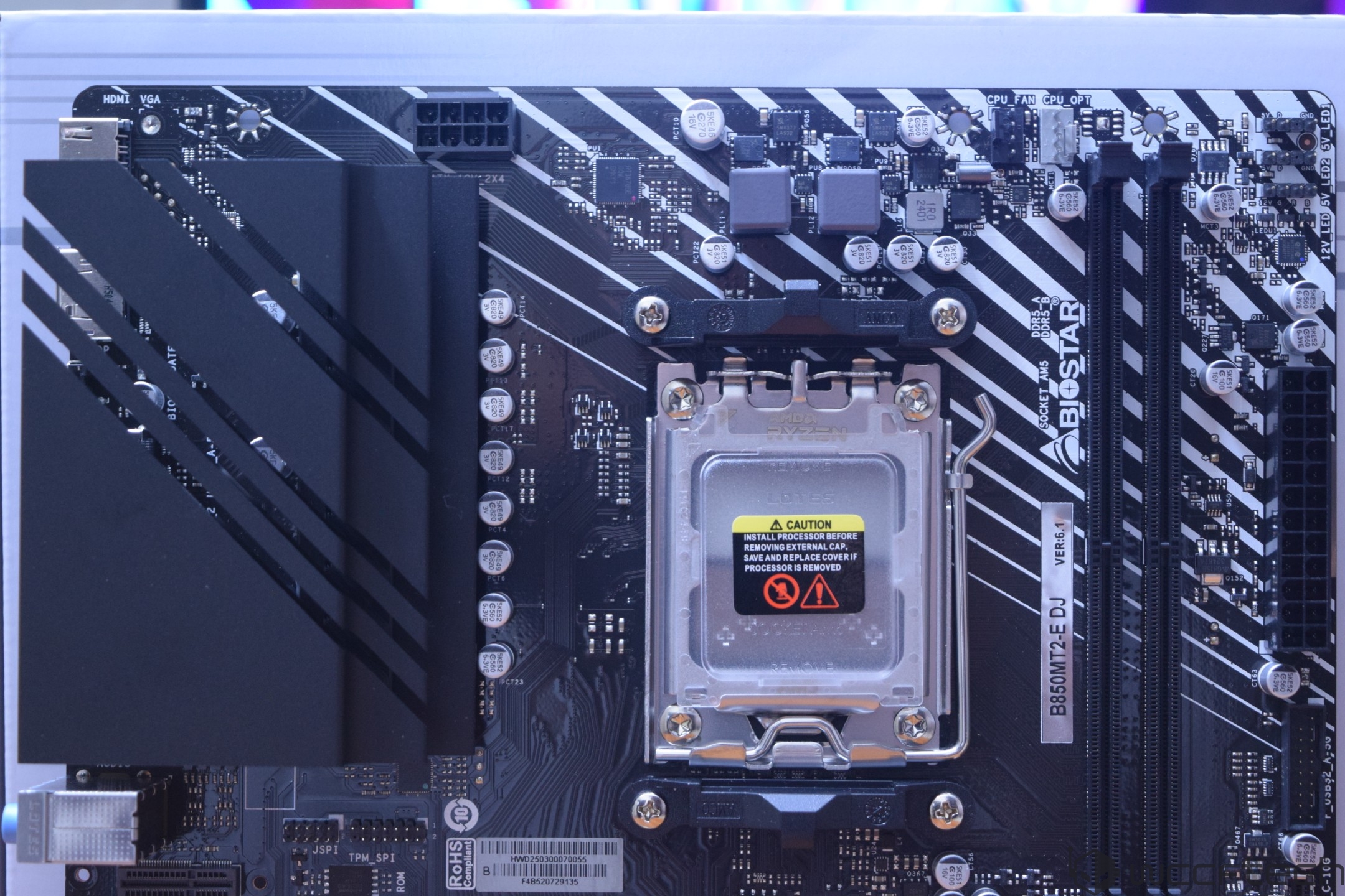 The Biostar B660M2-E D4 motherboard is shown with its LGA socket exposed and a caution label on the CPU slot.