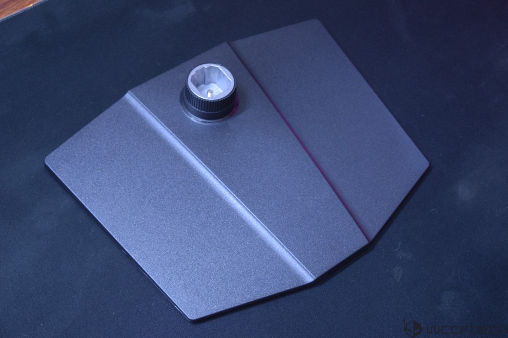 A metal monitor stand base with a hexagonal mounting point.