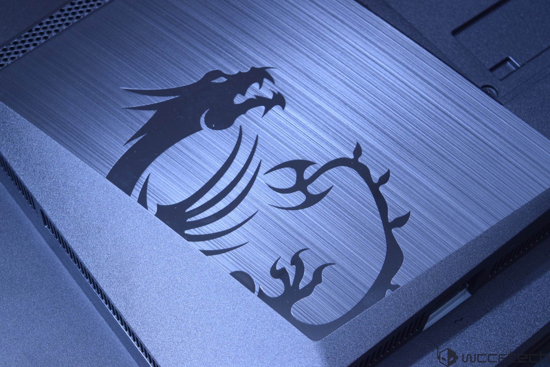 A close-up of an MSI laptop featuring the iconic dragon logo on a brushed metal finish.