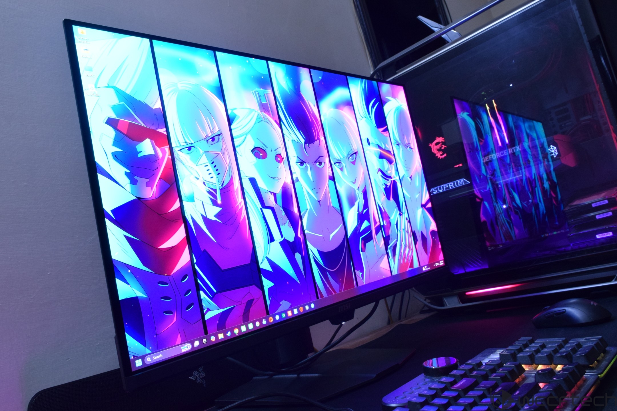 An MSI computer setup with a Razer monitor displaying vibrant anime art in a dual-screen configuration, featuring the 'GeForce RTX' logo on the case.