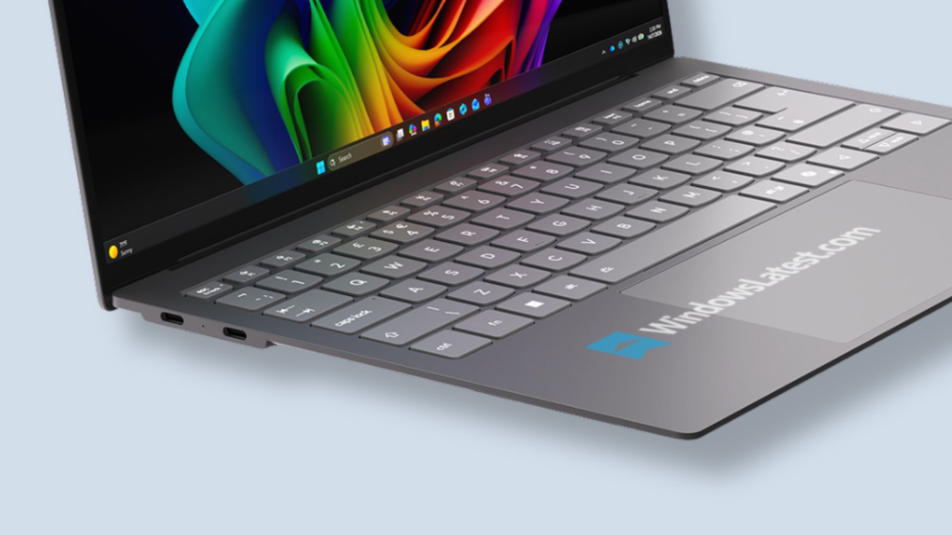 A laptop displaying the Windows 11 taskbar with visible apps and a 'WindowsLatest.com' label on the surface.