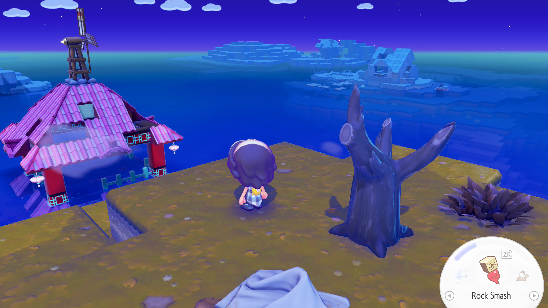 A character in 'Fae Farm' stands on a cliff overlooking a pink-roofed house with a windmill by the sea, with a prompt in the corner showing the 'Rock Smash' action.